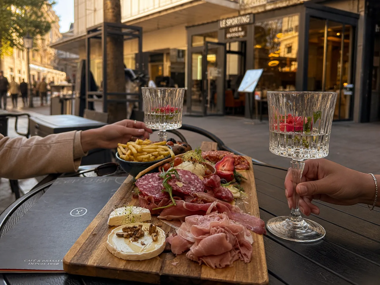 Une planche de charcuterie et deux verres en terrasse au Bistrot