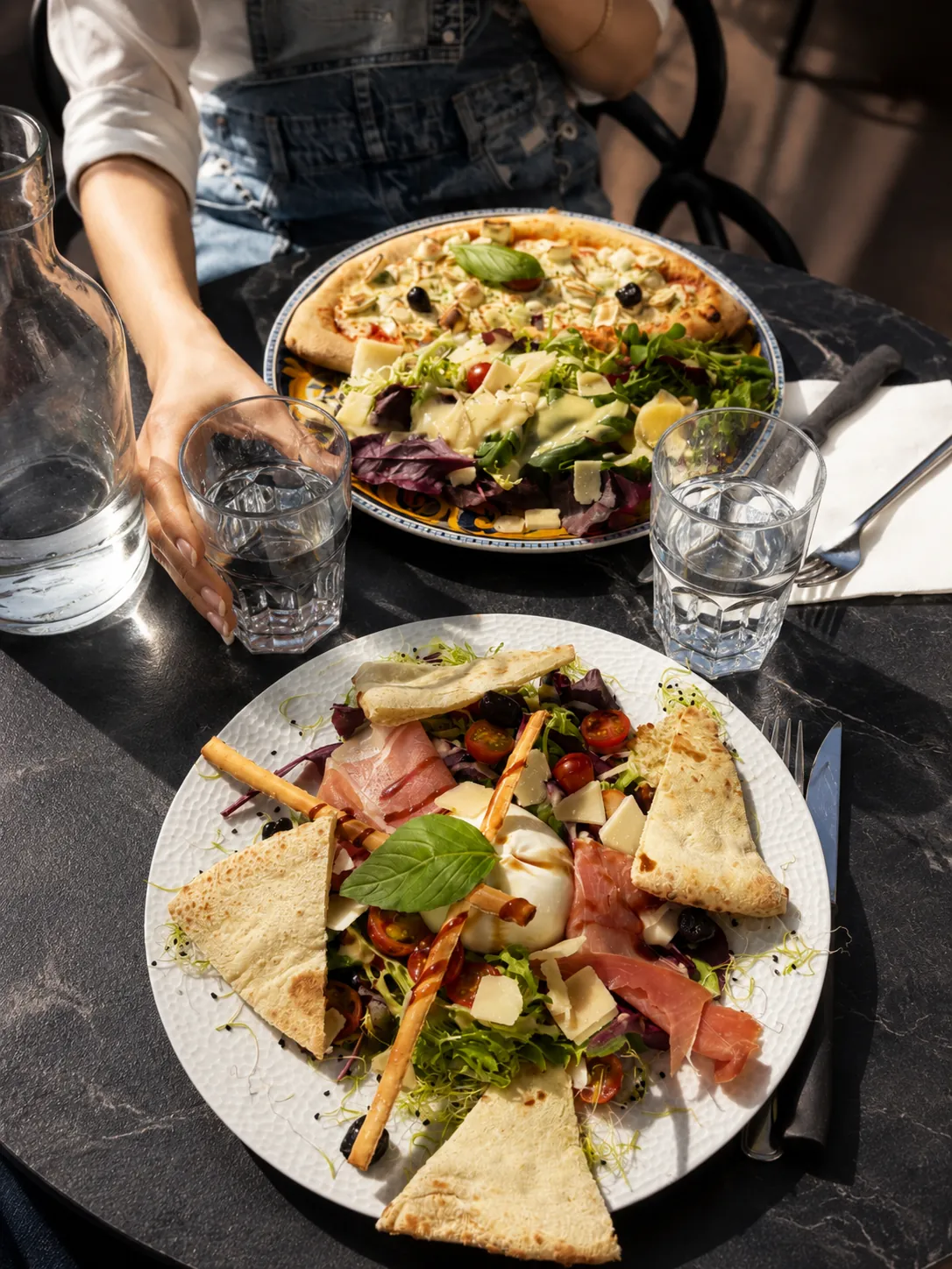 Une pizza et une salade servies en terrasse au Café-Brasserie